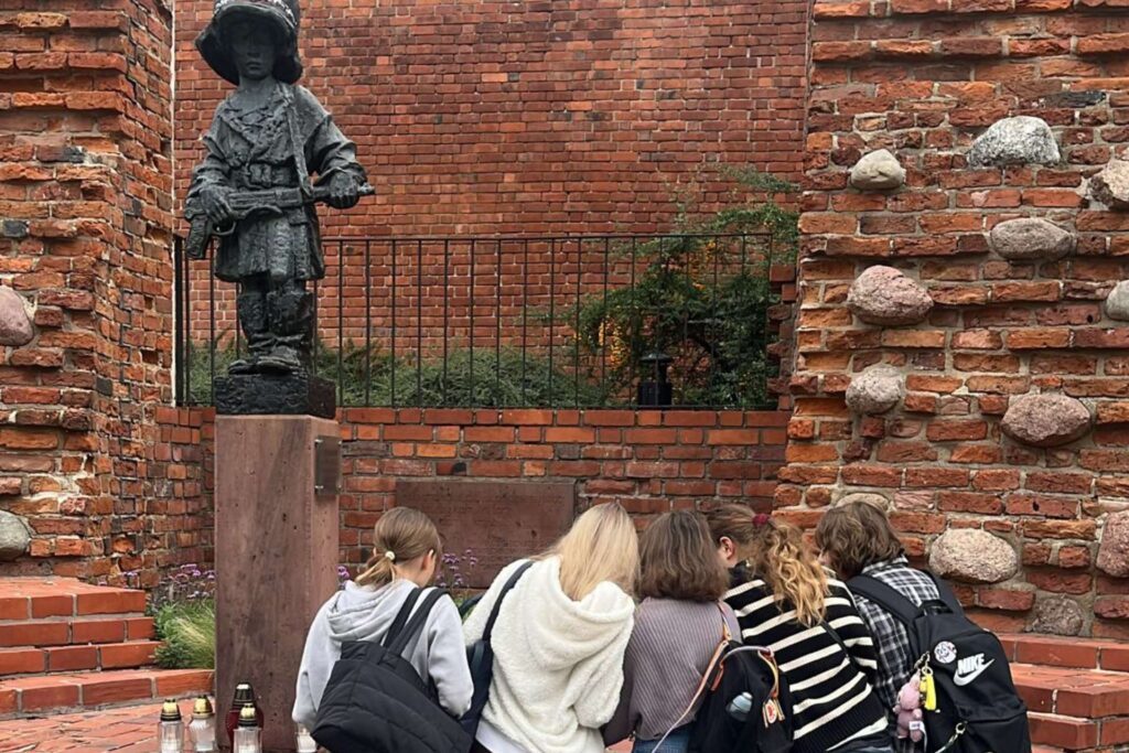 Grupa młodzieży przy pomniku Małego Powstańca w Warszawie podczas gry miejskiej „Szare Szeregi”.